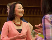 A woman smiling and gesturing with her hands.